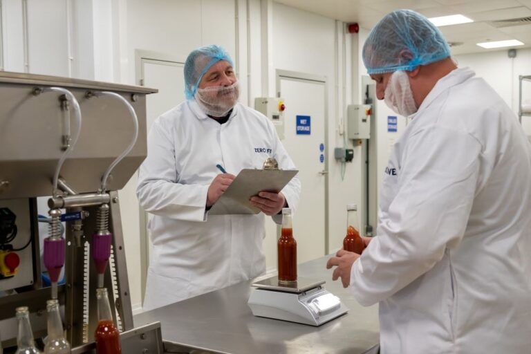 Food technologists in white coats analysing waste