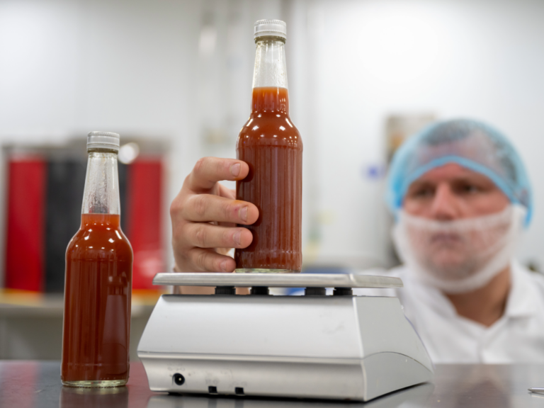 Technologist weighs bottle on scales