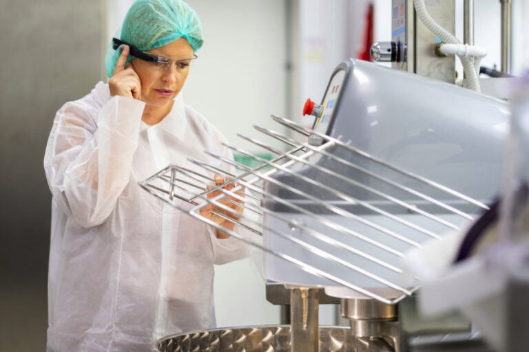 Lady practicing food safety in an industrial kitchen