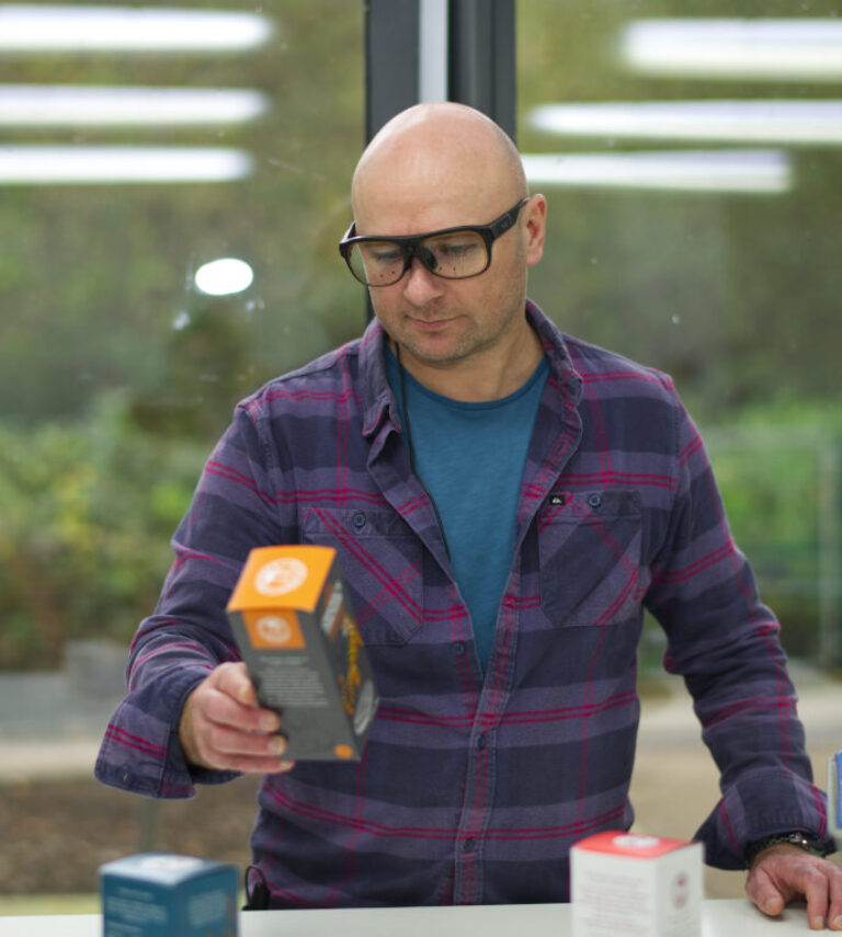 Man with eye tracking glasses holding package design for study