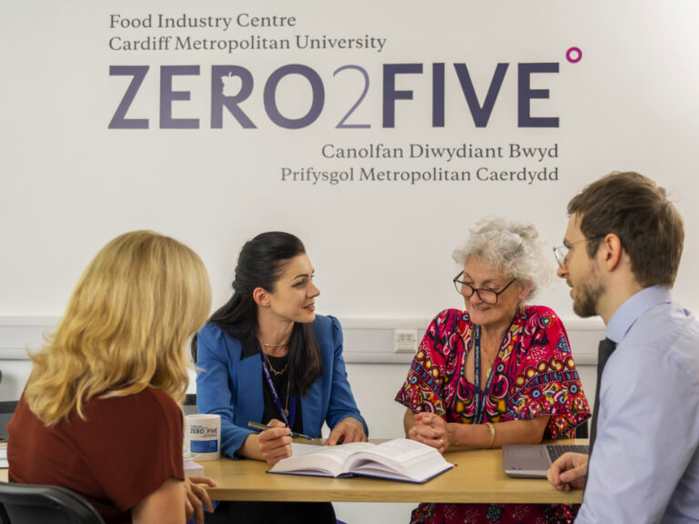 People discussing business around the ZERO2FIVE table