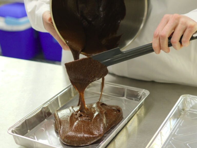 Pouring chocolate cake mix into foil baking tray