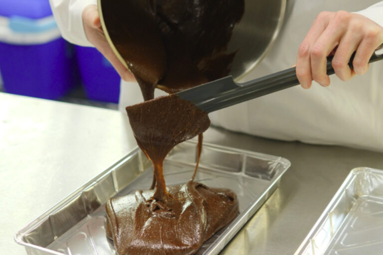 Pouring chocolate cake mix into foil baking tray