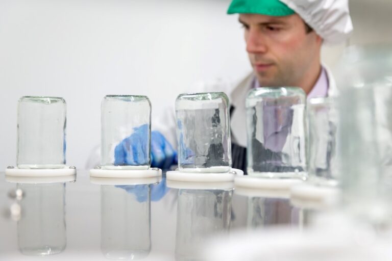 Food technologist using bottling machine