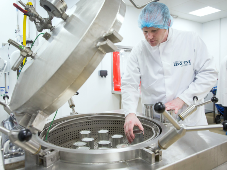 Food technologist using canning equipment