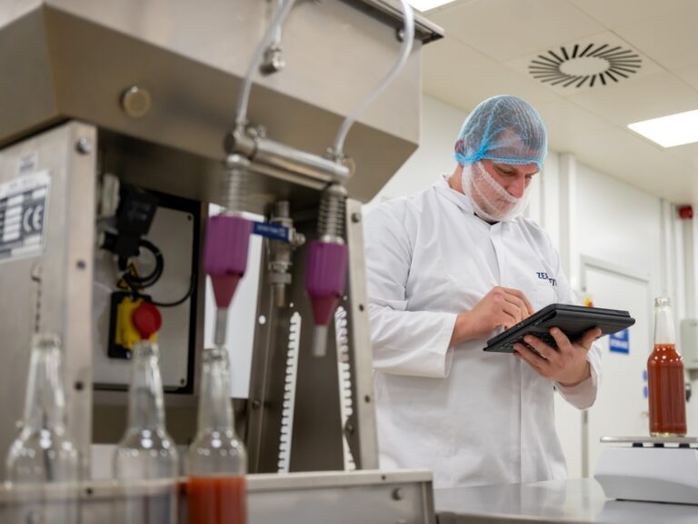 Food production operative with a tablet PC in a factory