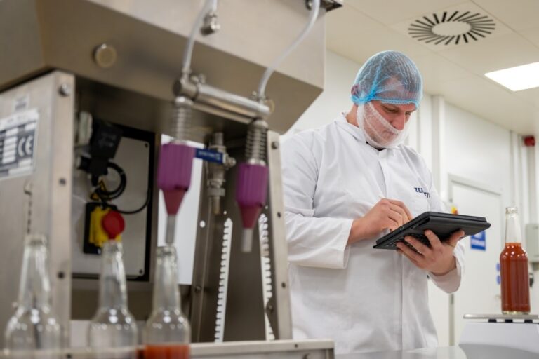 Food production operative with a tablet PC in a factory