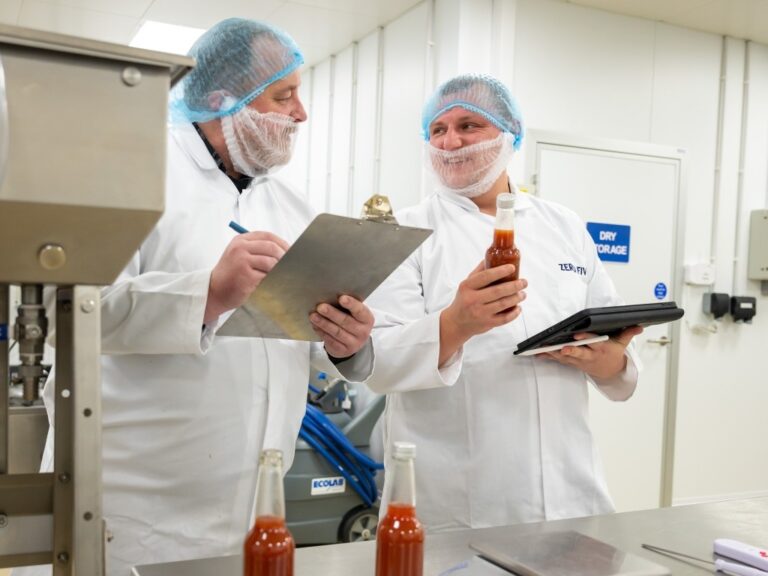 Two food manufacturing operatives with clipboards