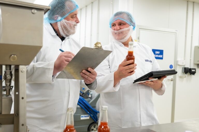 Two food manufacturing operatives with clipboards